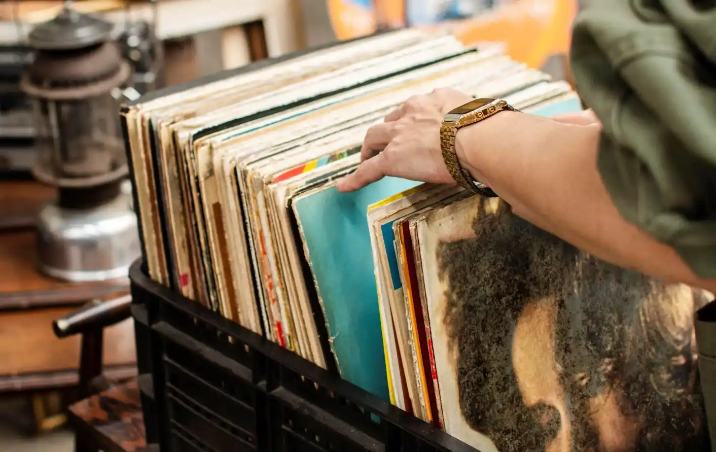 Männerhand mit Casio Goldarmbanduhr stöbert durch Schallplatten