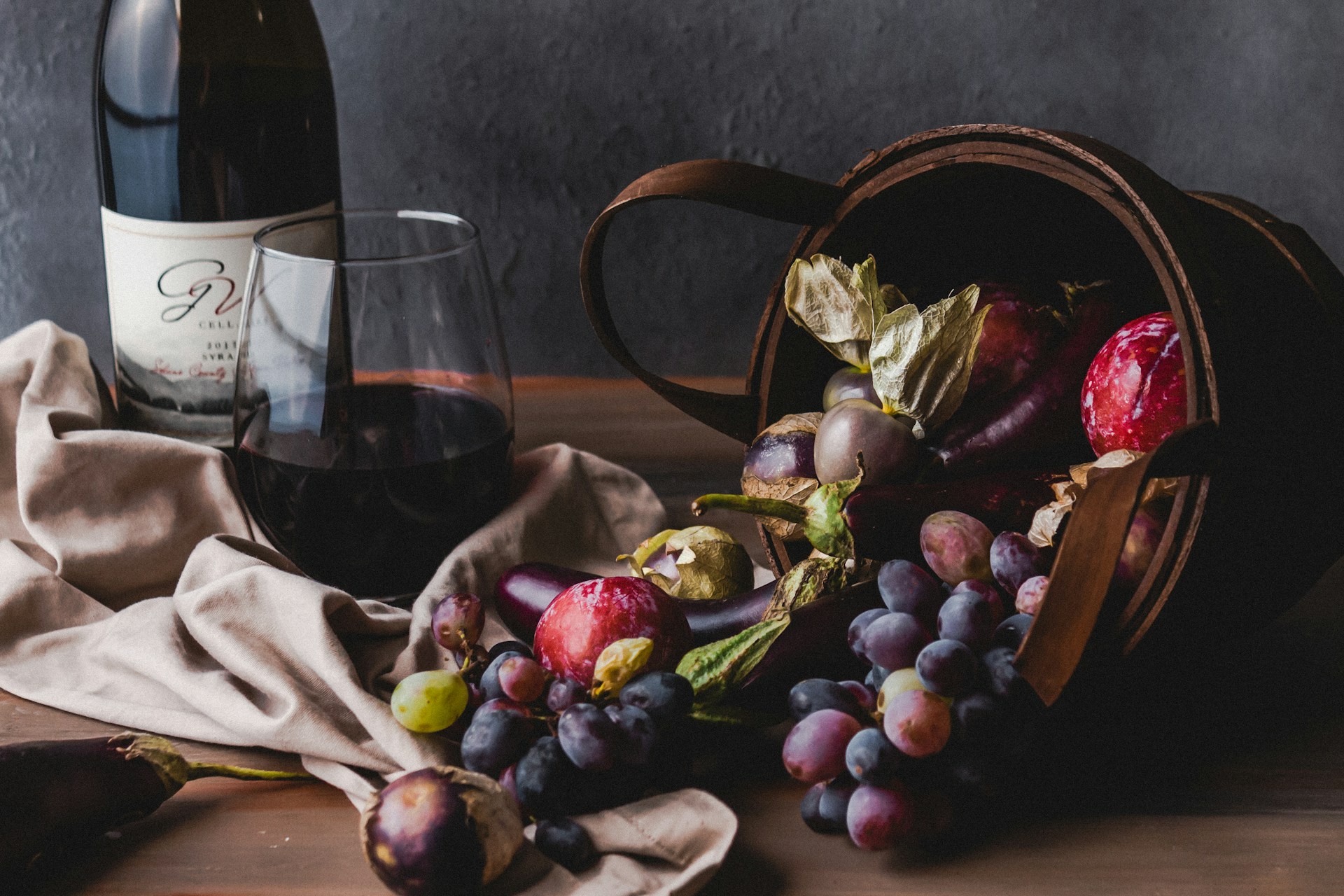 Bester Rotwein im Glas neben Trauben auf einem Tisch