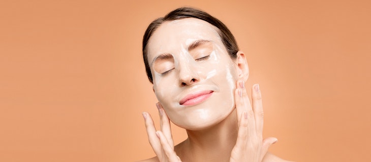 Frau nutzt Hautpeeling im Gesicht