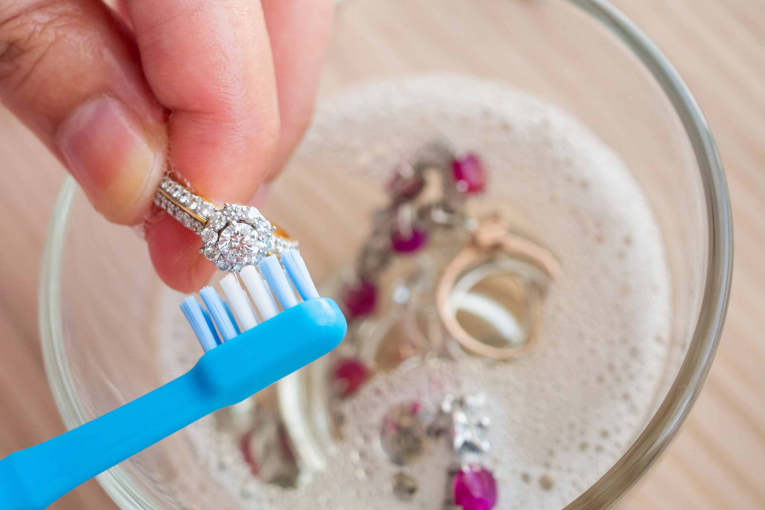 Eine Frau reinigt ihren Silberschmuck sanft mit einer Zahnbürste